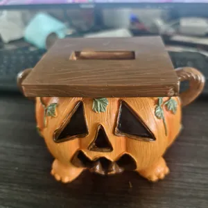 Detailed view of Halloween pumpkin tissue box with carved face and wood-textured lid