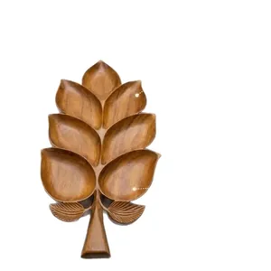 Detailed macro view of a handcrafted wooden tray in the shape of a multi-lobed leaf.