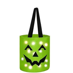 Close-up detail of a bright green Halloween candy bucket featuring glowing LED lights