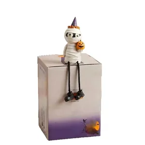 Cute Halloween mummy figurine sitting on a spooky pumpkin theme display box decor