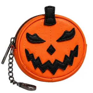 Detalle de un mini monedero con forma de calabaza y llavero de metal para Halloween.