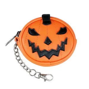 Primer plano de un mini monedero con forma de calabaza y cadena plateada de Halloween