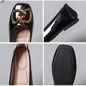 Detail view of black patent leather ballet flats with gold buckle and soft padded insole