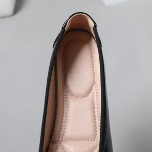 Close-up showing the soft padded beige lining and neat stitching of black ballet flats