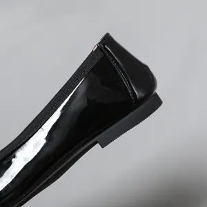 Detail shot of black patent leather ballet flat heel with elastic edge and thin sole.