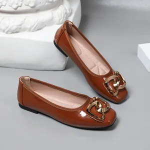 Detailed shot of brown patent leather ballet flats with a stylish gold-tone buckle