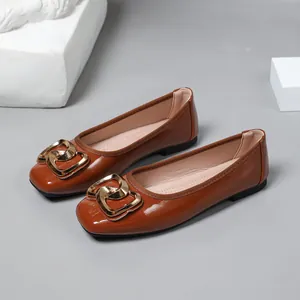 Elegant brown patent leather ballet flats featuring a stylish gold heart buckle detail.