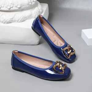 Close-up view of elegant glossy blue ballet flats featuring a stylish golden heart buckle