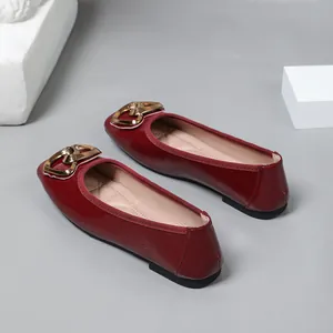 Detail view of stylish burgundy square toe ballet flats with elegant gold heart buckle