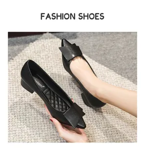 Détail de chaussures pointues en cuir noir avec grand nœud et petit talon carré