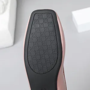 Close-up of the non-slip rubber sole on a pink patent leather square toe flat shoe.