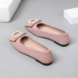 Close-up of pink ballet flats featuring an elegant pearl buckle and square bow detail.
