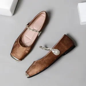 Detailansicht brauner Satin-Mary-Jane-Schuhe mit perlenbesetztem geflochtenem Riemen