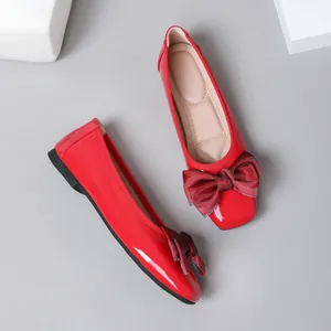 Red patent leather ballet flats with a stylish bow on the square toe, elegant design