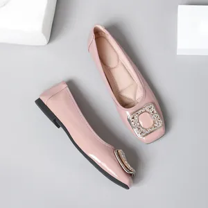 Elegant pink patent leather flat shoes featuring a sparkling rhinestone square buckle detail