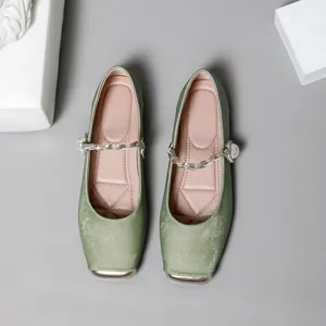 Draufsicht auf salbeigrüne Mary Jane Flats aus Satin mit Perlenkette