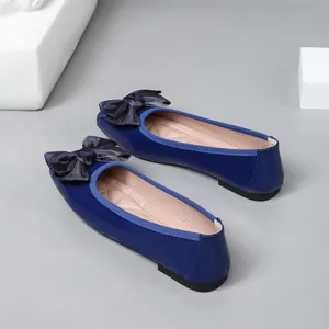 Elegant royal blue patent leather ballet flats with a stylish black satin bow detail