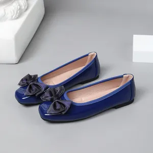 Detailed view showing the glossy finish and elegant fabric bow on blue ballet flats.