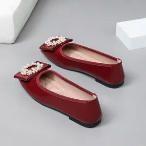 Detail view of wine red ballet flats with pearl embellished square buckle design