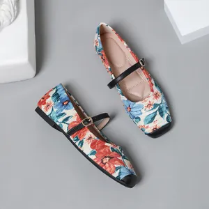 Detail view of floral print Mary Jane flats with black toe cap and buckle strap