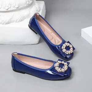 Elegant blue patent leather ballet flats with pearl and rhinestone circle bow detail.