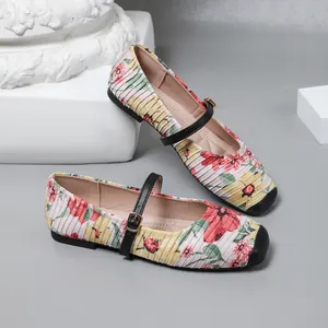 Close-up of vintage French Mary Jane flats with floral print and pleated fabric detail