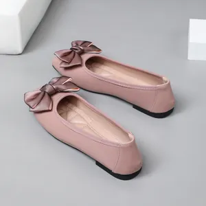 Detailed view of pink ballet flats featuring an elegant satin bow decoration.