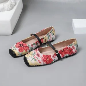 Close-up detail of French vintage Mary Jane ballet flats with vibrant red floral print.