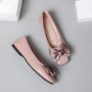 Overhead view of glossy pink ballet flats featuring elegant satin bow detail