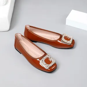 Elegant brown patent leather square toe flats with sparkling rhinestone buckle detail.