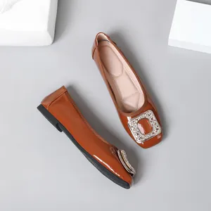 Elegant brown patent leather flat shoes featuring a sparkling rhinestone square buckle