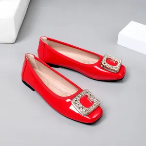 Detailed shot of red patent leather ballet flats with sparkling rhinestone square buckle