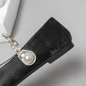 Detailansicht französischer Mary-Jane-Flats mit geflochtenem Goldriemen und Perle