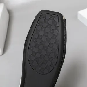 Nahaufnahme des rutschfesten Kleeblattmusters auf der schwarzen Sohle der Schuhe.