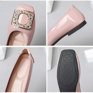 Detailed view of pink patent leather flats with rhinestone buckle and textured sole