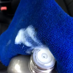 Detailansicht eines blauen Mikrofasertuchs mit weißem Reinigungsschaum zur Reinigung.