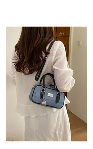 Rear view of a woman wearing a blue denim bowling bag with a white blouse for a casual look