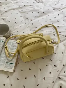 Vista dettagliata di una borsa a cuscino in pelle martellata gialla su lenzuola