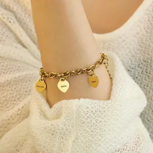 Gros plan d'un bracelet cœur en acier doré avec gravure personnalisée sur le bras