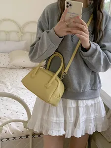 Primo piano di una borsa a cuscino gialla stile coreano tenuta da modella