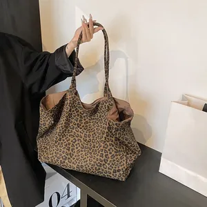 Detail view of a large leopard print canvas tote bag in a stylish and casual urban setting