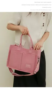 Vista detallada de la bolsa tote de lona rosa multibolsillo con correa ancha ajustable