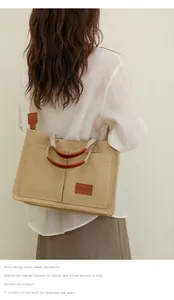 Bolso de lona grande con múltiples bolsillos y correa de hombro ancha en la modelo.