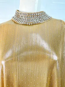 Detailed macro view of a gold shimmering dress featuring a luxury rhinestone collar