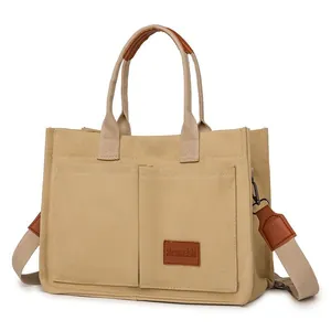 Vista detallada del bolso tote de lona beige con diseño multibolsillos y correa ancha