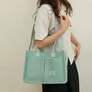 Elegante bolso tote de lona verde menta de gran capacidad y diseño multibolsillo en modelo