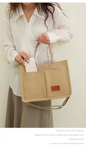 Vista detallada del bolso tote de lona caqui con múltiples bolsillos llevado por modelo