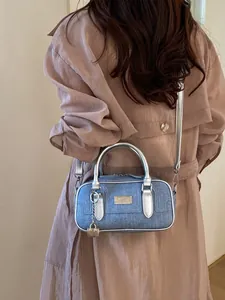 Stylish blue denim bowling bag with silver trim and crossbody strap for women's daily commute