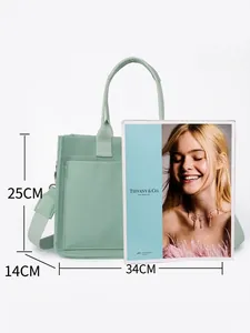 Bolso tote de lona verde menta de gran capacidad con correa ancha comparado con revista A4
