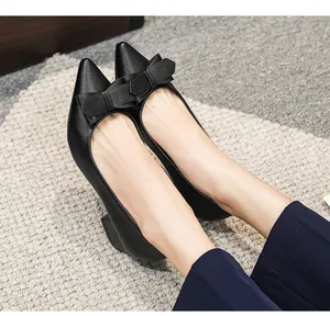 Gros plan sur des escarpins noirs à bouts pointus avec un nœud décoratif chic